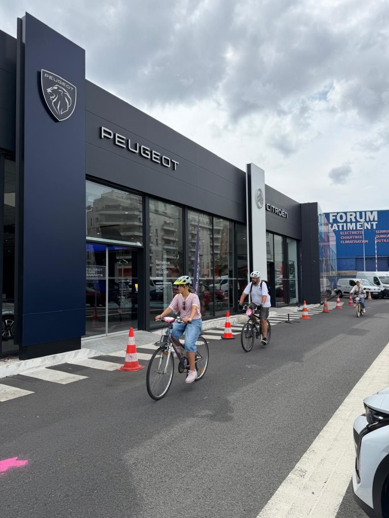 Participants à vélo devant les concessions Neubauer